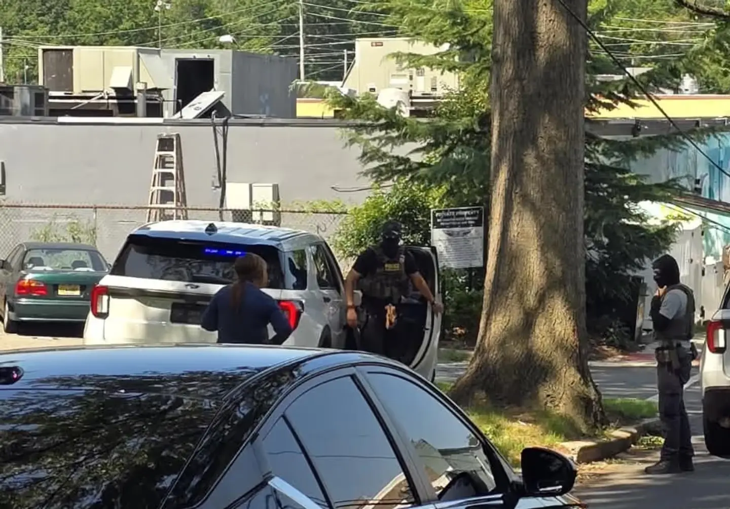 Tactical personnel and law enforcement officers gather near the scene.