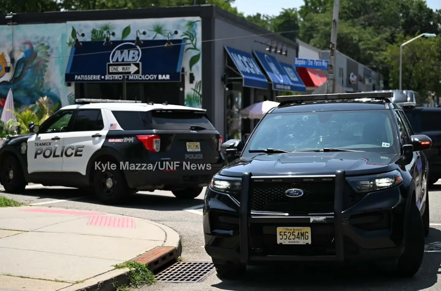 Teaneck Police vehicles direct traffic away from the scene near Queen Anne Road.